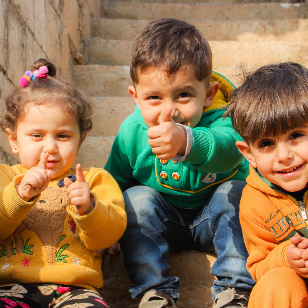 Three children sitting on a step