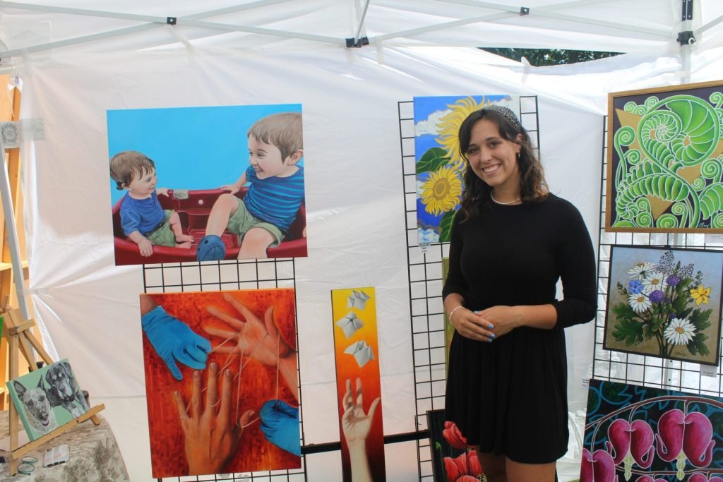 Jax Perry in front of a few of her paintings.