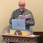 Bruce Whiteacre, poetry reading at podium