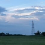 Standing tall against the sunset sky is an old tower from the former amusement park, a reminder of yesterday.